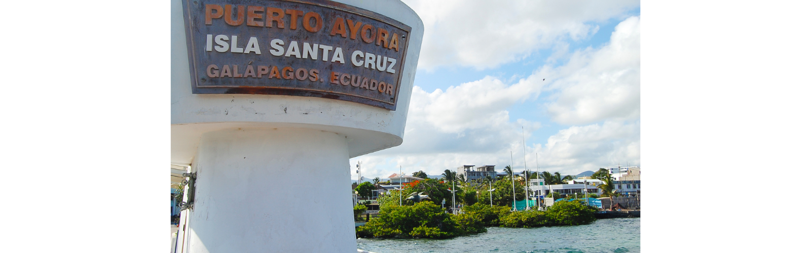 Marina of Santa Cruz with a large sign marking the island.